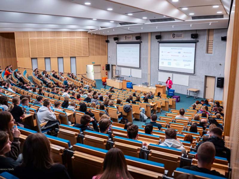 Tłumy ludzi słuchają wykładu na Auli podczas Uniwersyteckiej Giełdy Pracy.
